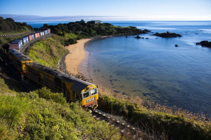 A TasRail locomotive passes along a coastline in Tasmania. Credit: TasRail.